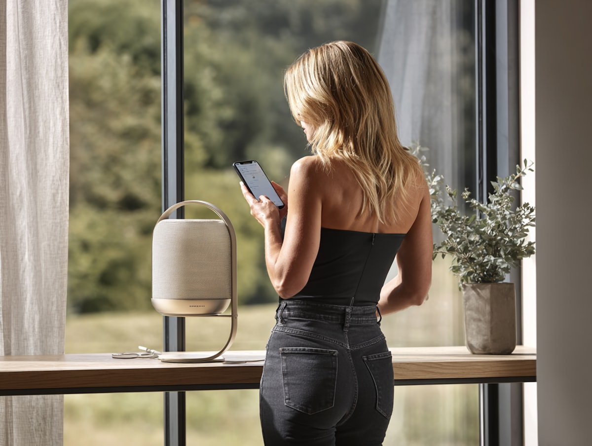 Auracast Bluetooth ses yayınını temsil eden akıllı telefon ve kablosuz hoparlör kullanılan ev ortamı